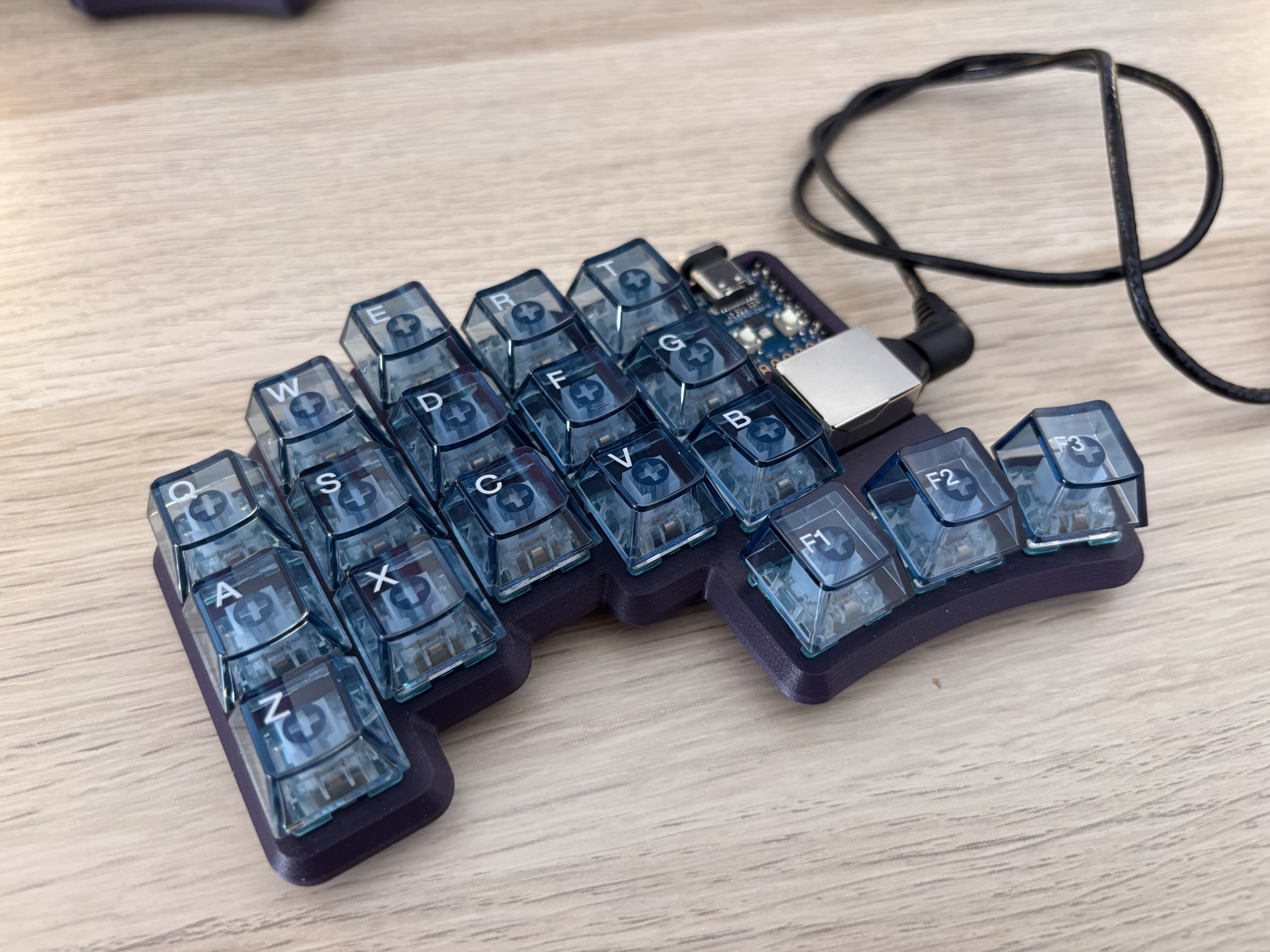 Half a split keyboard with transparent blue keycaps